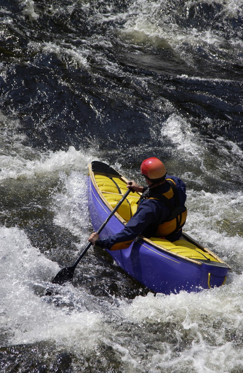 Solo Canoeist paddling in whitewater